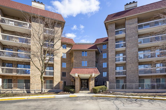 Front view of a multi-story apartment building with balconies.