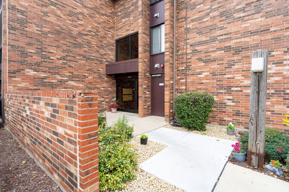 Front view of a brick building with a walkway and entrance.