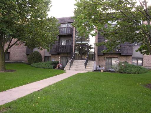 Front view of a multi-story apartment building with balconies.