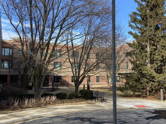 Front view of a multi-story brick building with numerous windows.