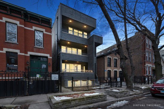 Front view of a modern multi-story apartment building with balconies.