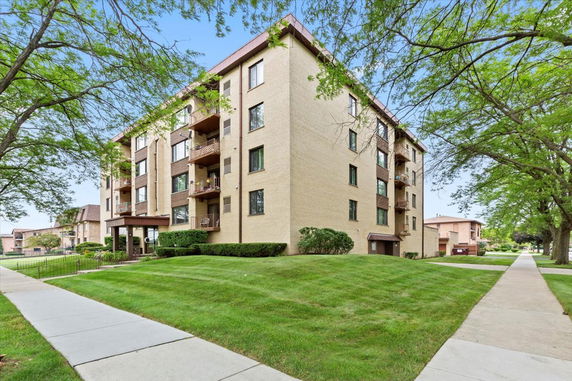 Front view of a multi-story apartment building with balconies.
