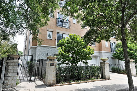 Front view of a multi-story residential building with gated entrance.