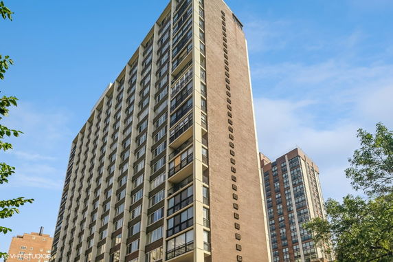 Front view of a high-rise residential building with multiple balconies.