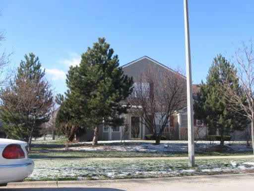 Front view of a two-story house with trees in the front yard.