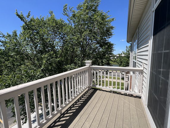 View from a balcony showing trees and nearby road.