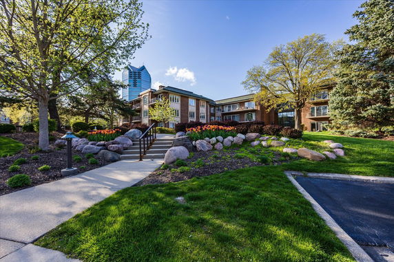 Front view of a multi-story building with landscaped garden.
