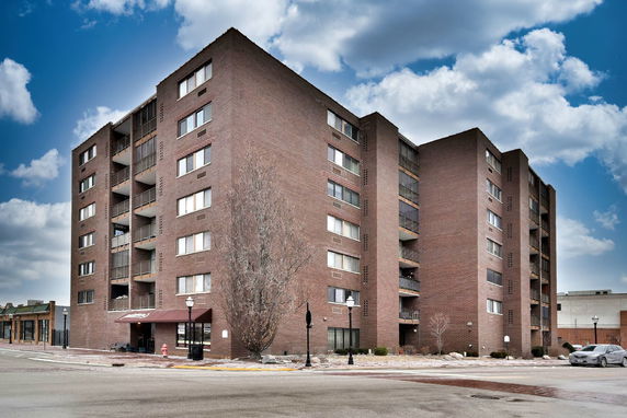 Front view of a multi-story apartment building with brick exterior.
