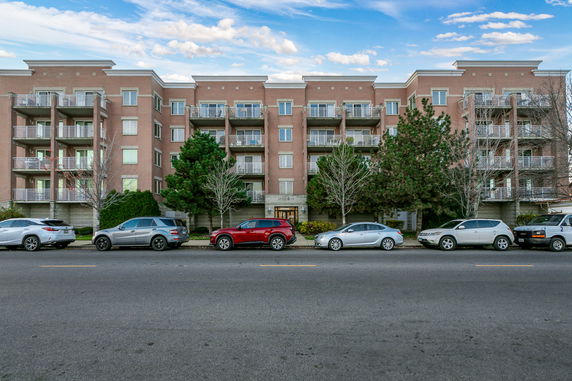 Front view of a multi-story apartment building with balconies.