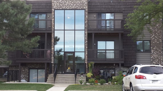Front view of a multi-story apartment building with balconies.