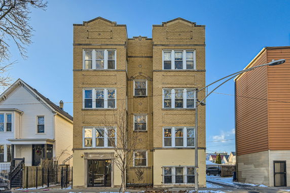 Front view of a four-story brick apartment building.