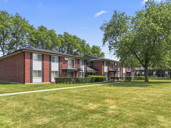 Front view of two-story brick apartment buildings with balconies.