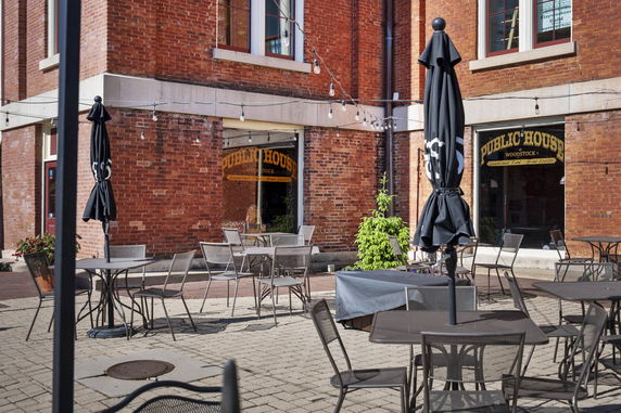 Front view of a brick building with outdoor seating.