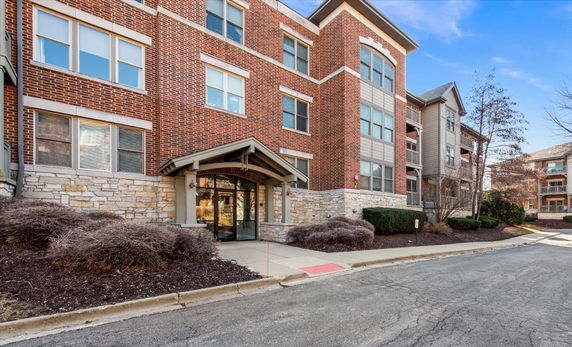 Front view of a multi-story brick condominium building.