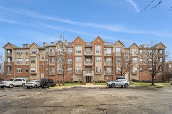 Front view of a multi-story residential building with brick facade and balconies.