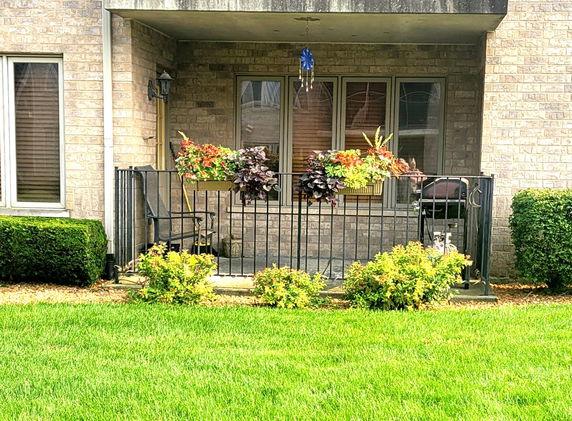 Front view of a house with a small patio and flower boxes.