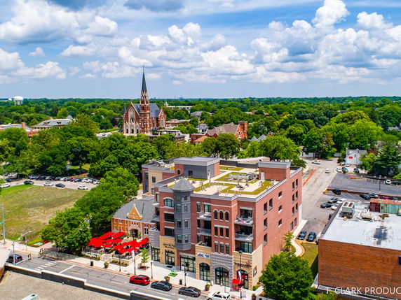 Panoramic view of a cityscape with a church steeple and multi-story building.
