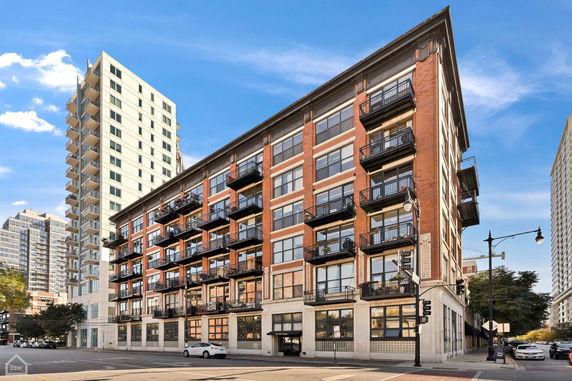 Front view of a multi-story brick apartment building with balconies.