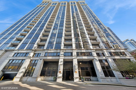 Front view of a high-rise building with balconies and large windows.