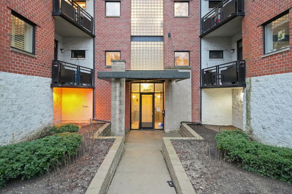 Front view of a multi-story building with a central entrance and balconies.