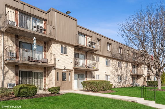 Front view of a multi-story apartment building with balconies.