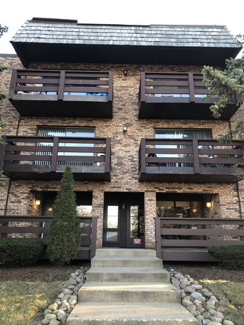 Front view of a multi-story apartment building with balconies.