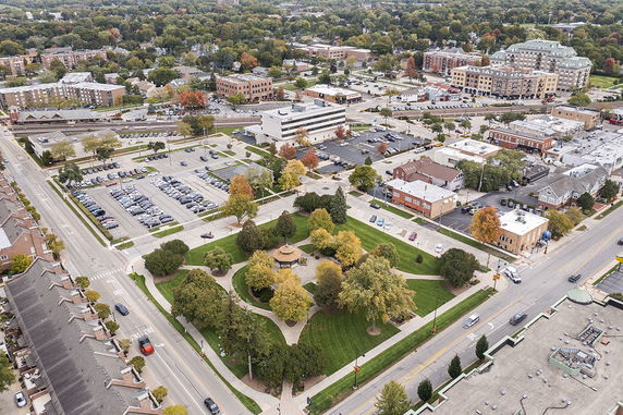 Panoramic aerial view of a town with streets, buildings, and a central park area.