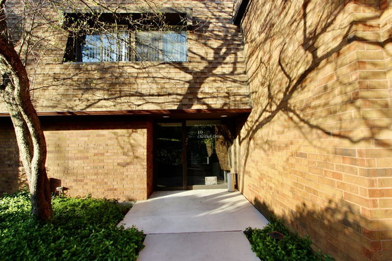Front view of a brick building entrance with a glass door.