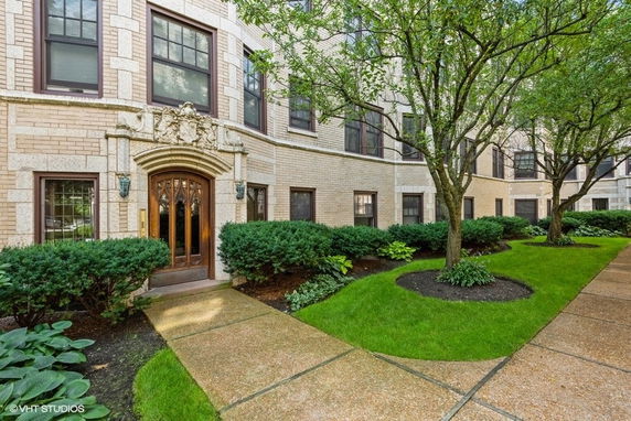 Front view of a multi-story building with a decorative entrance and large windows.