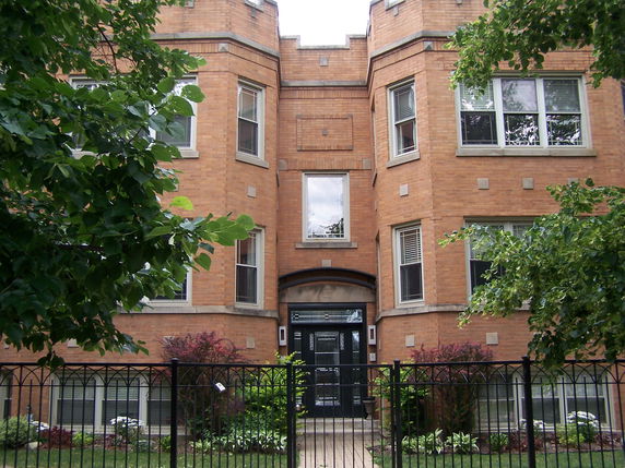Front view of a multi-story brick building with a central entrance.