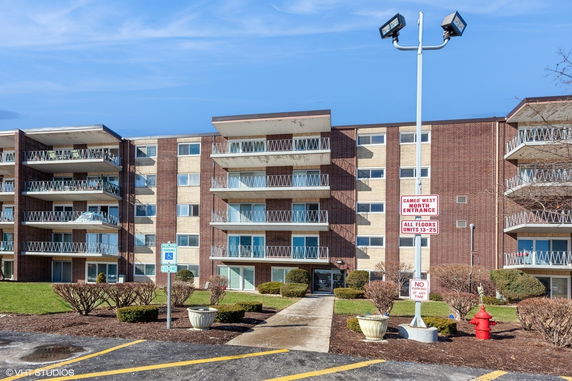 Front view of a multi-story apartment building with balconies.