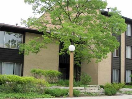 Front view of a multi-story residential building with rectangular windows and a central entryway.