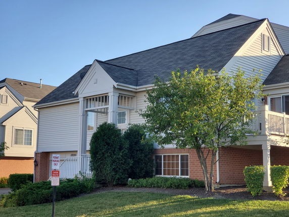 Front view of a multi-story house with a gable roof and balcony.