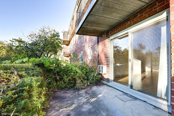 Side view of an apartment building with brick exterior and sliding glass door.