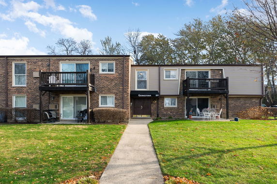 Front view of a two-story residential building with brick facade and balconies.