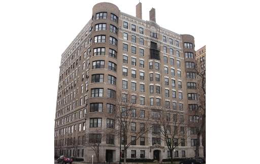 Front view of a multi-story brick building with multiple windows.