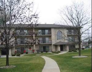 Front view of a three-story apartment building with balconies.