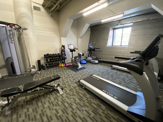 Indoor fitness area with gym equipment and exercise machines.