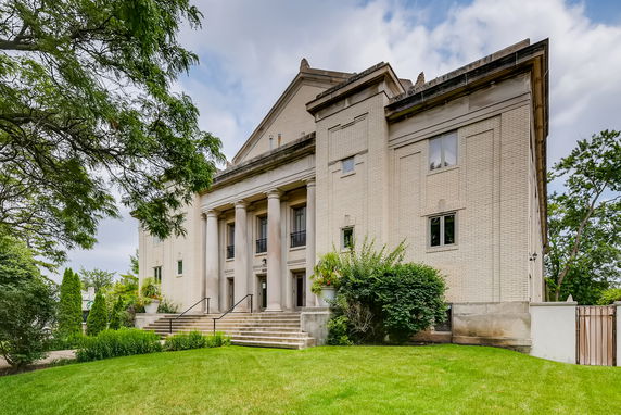 Front view of a large building with columns and multiple windows.