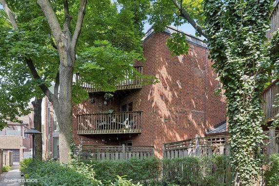 Front view of a three-story brick residential building with balconies.