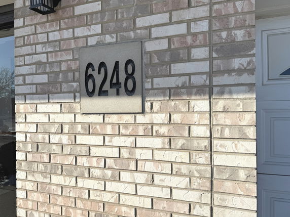 Front view of a brick house with the number 6248 displayed.