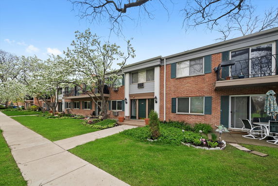 Front view of a two-story residential building with a brick facade and multiple entryways.