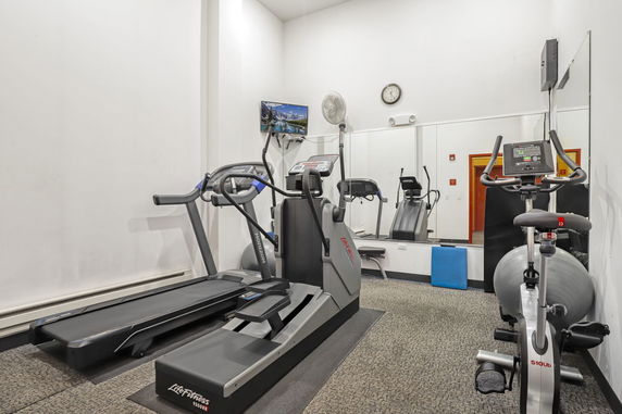 Indoor gym area with exercise equipment including a treadmill and stationary bike.