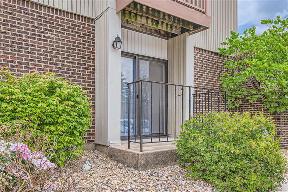 Front view of a building with a small balcony and sliding glass door.