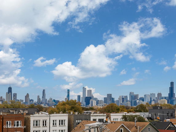 Skyline view of a city with modern skyscrapers and residential buildings in the foreground.