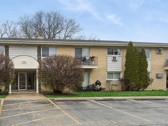 Front view of a two-story apartment building with parking area.