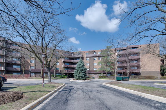 Front view of a multi-story apartment building with balconies.