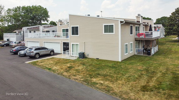 Front view of a two-story building with balconies and garages.