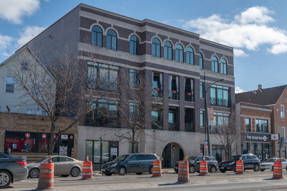 Front view of a multi-story brick building with arched windows.