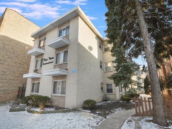Front view of a three-story condominium building with balconies.